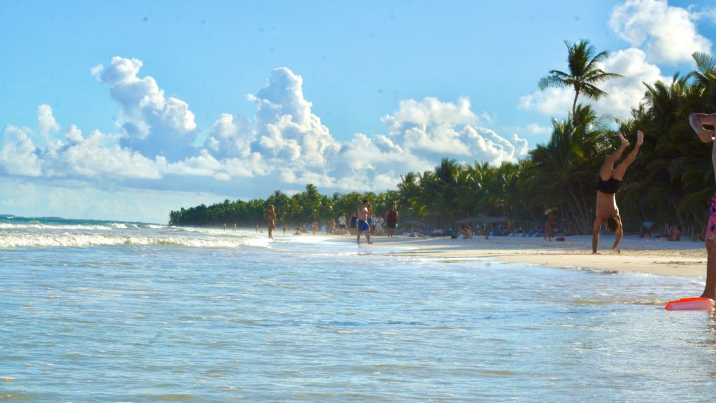 man doing a handstand on a beach in Tulum